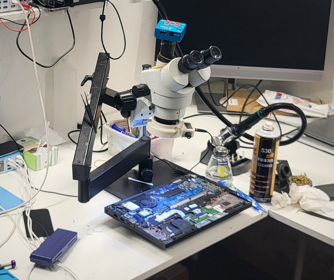 Geopende laptop onder de microscoop in onze werkplaats
